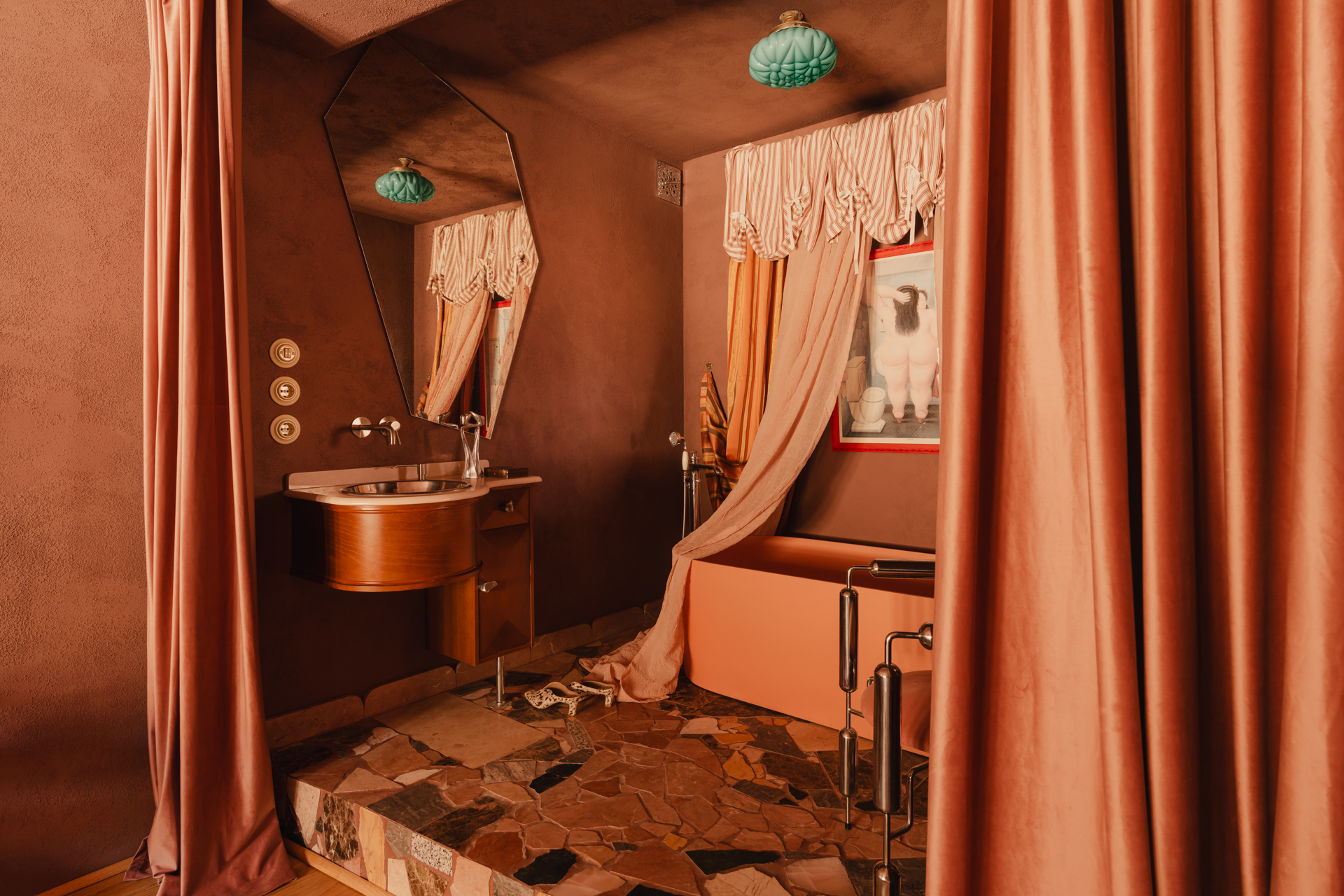 A raised platform features a tub behind a curtain, with a sink and a geometric shaped mirror.