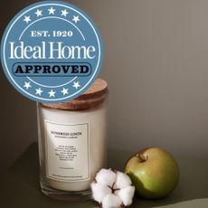 H&M Sundried Linen Candle with an apple and a flower next to it, and ideal home approved badge