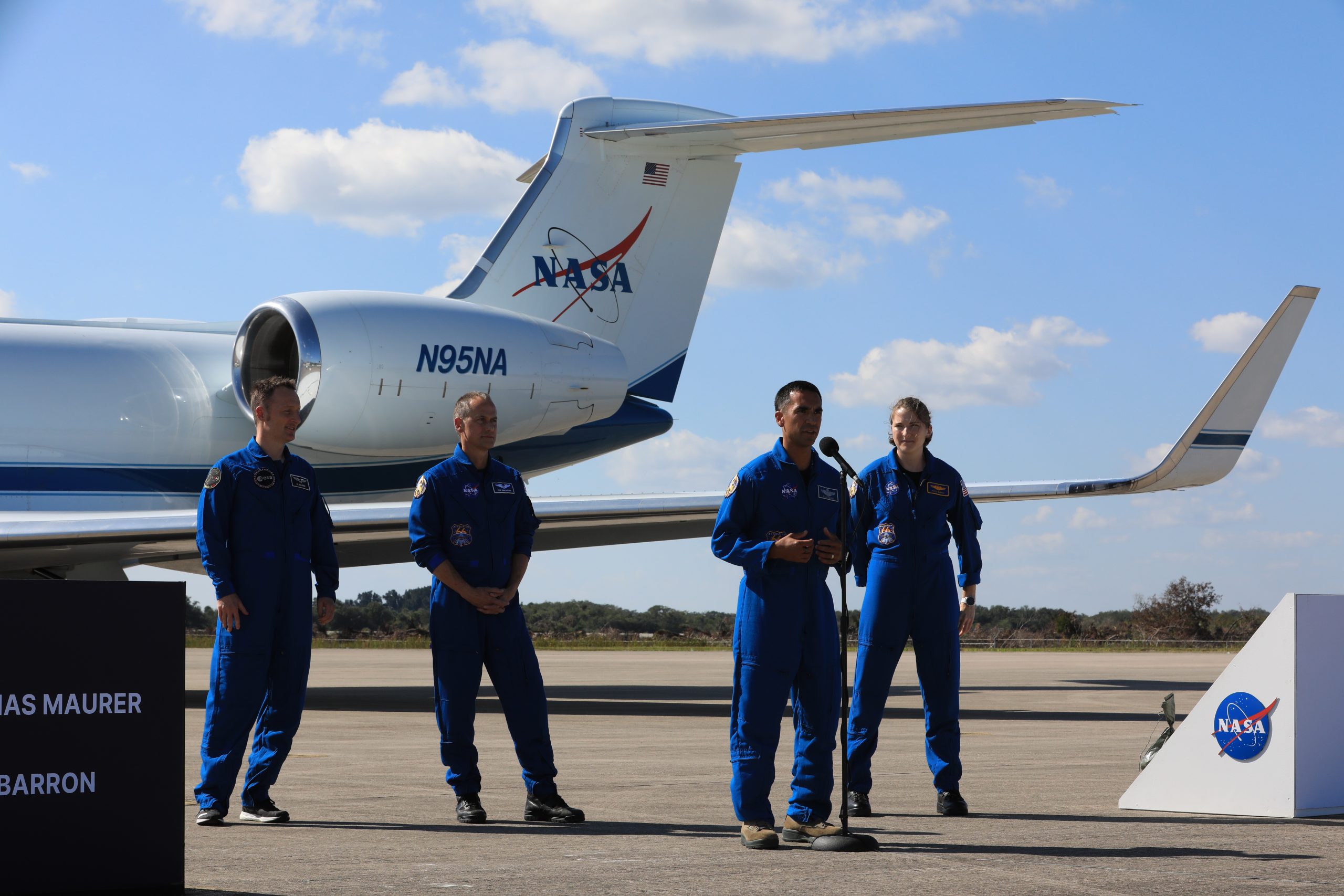 The astronauts who will fly on NASA’s SpaceX Crew-3 mission participate in a media event following their arrival at the agency’s Kennedy Space Center in Florida on Oct. 26, 2021. Speaking at the microphone is NASA astronaut and spacecraft commander Raja Chari. Behind him from left is European Space Agency astronaut and mission specialist Matthias Maurer, and NASA astronauts Tom Marshburn, pilot, and Kayla Barron, mission specialist.