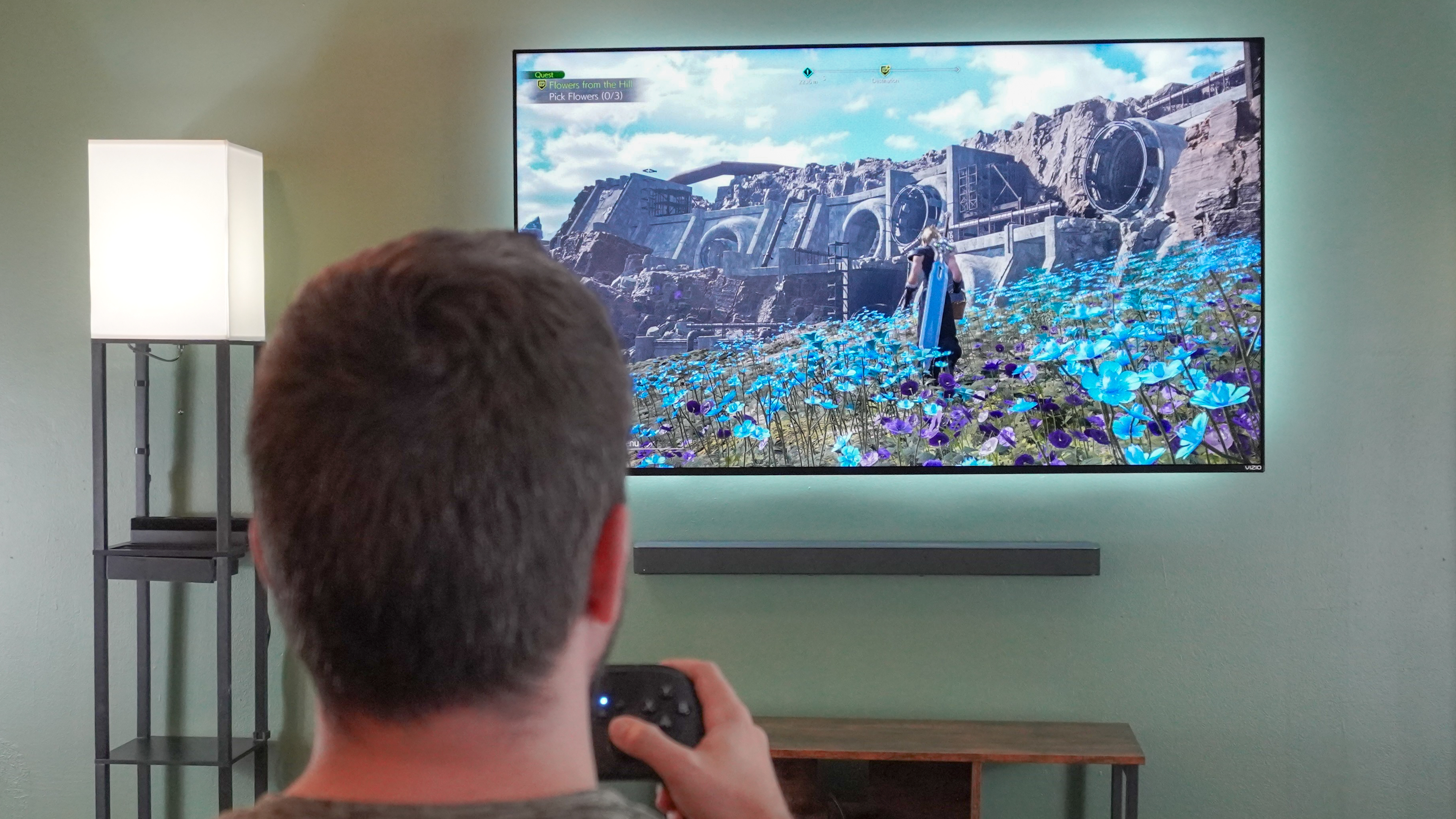 A person playing Final Fantasy VII Rebirth on a TV in the living room on a Framework Desktop