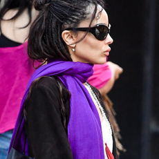 Zoe Kravitz is spotted stepping out in New York City. The 37 year old American actress wore a white top under a black coat paired with a vibrant purple scarf and black patent leather boots.