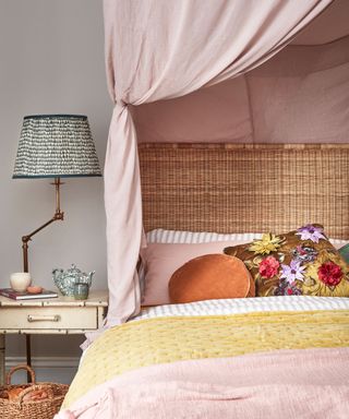 icker bedhead, pink canopy and bedlinen and green table lamp