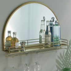 round mirror with glass bottle and wine glasses