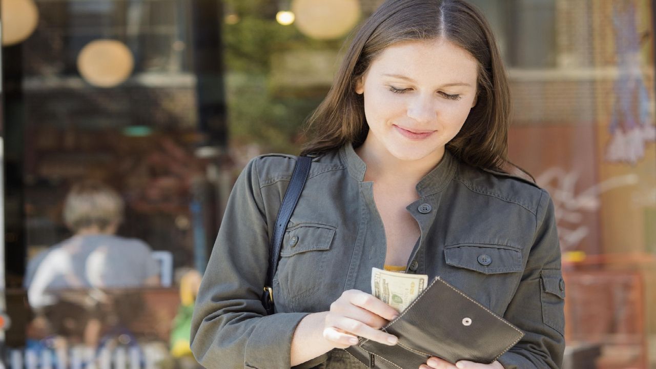 A young woman counts cash. 