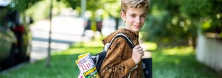 A young boy carrying a backpack