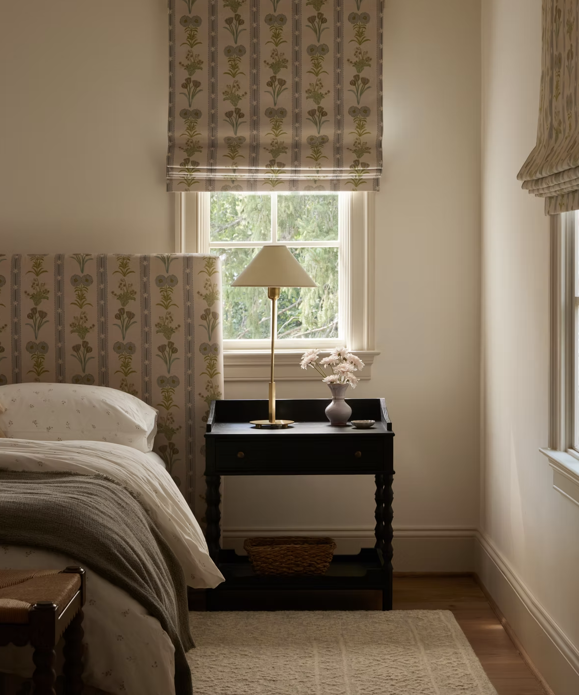 neutral bedroom with patterned fabric used for the headboard and window blind