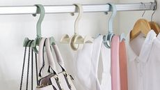Closet organizer hangers in different colors, holding purses and caps on rail inside closet