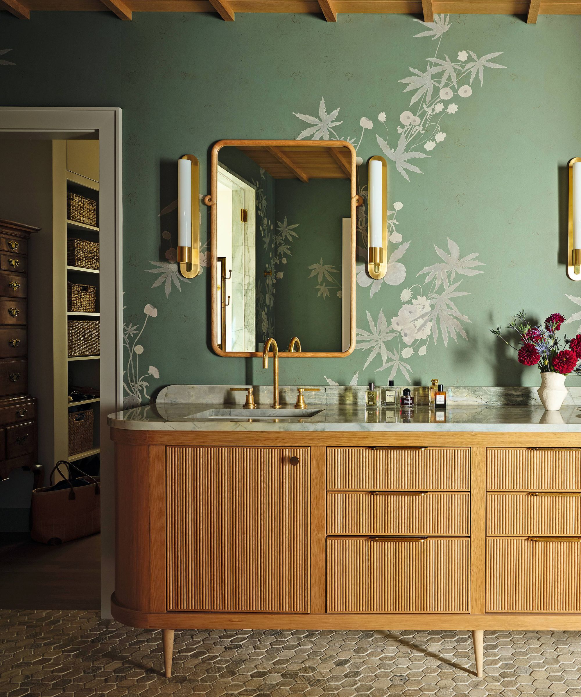 a green wallpapered bathroom with a timber clad ceiling and oak vanity