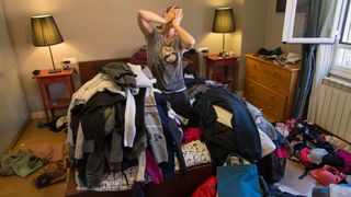 A woman surrounded by lots of clothes