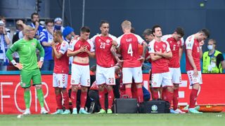 Denmark’s players formed a protective shield around Christian Eriksen