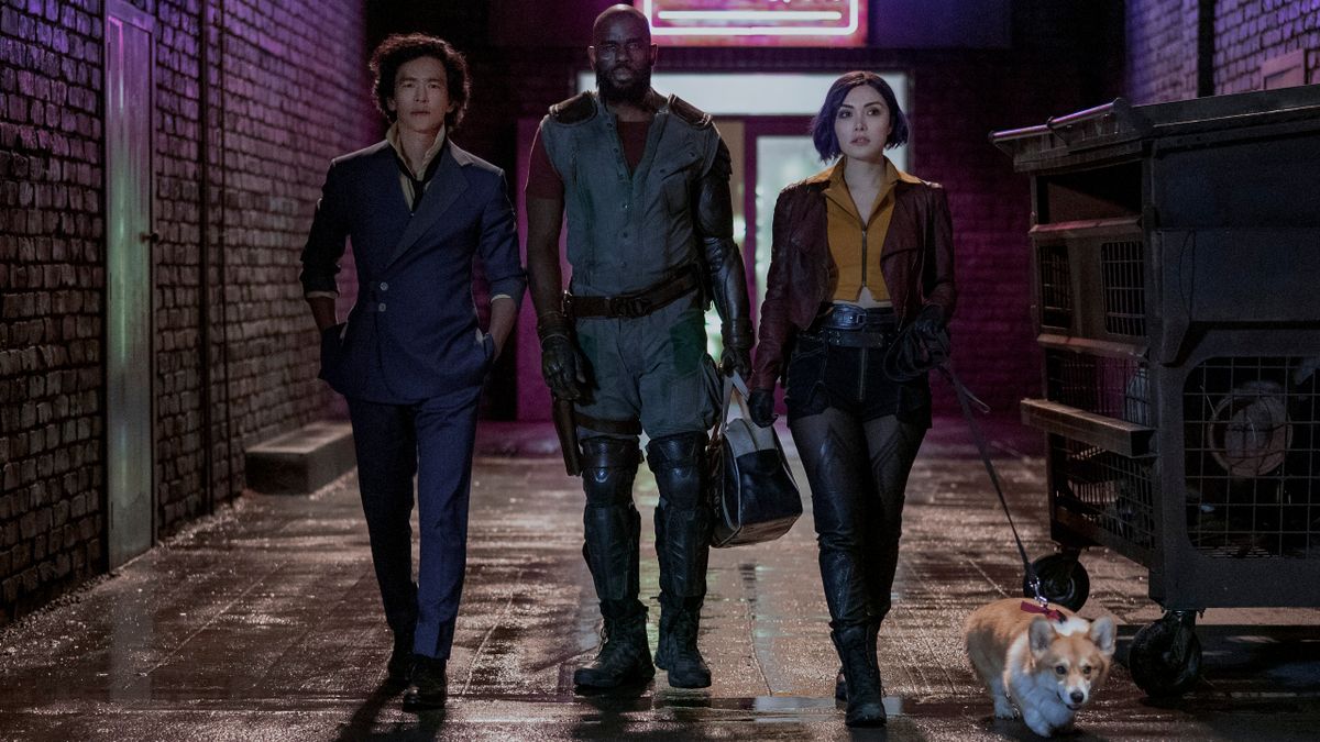 John Cho, Mustafa Shakir, and Daniella Pineda walking down an alley with Ein in Cowboy Bebop.