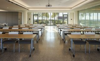 Learning space with tables and chairs, leading out into the rooftop garden