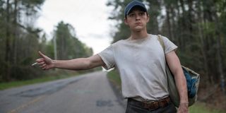 The Devil All The Time Tom Holland hitchhikes in the woods