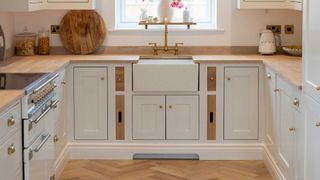 small cream Shaker kitchen with wooden worktops and Belfast sink to show the kitchen work triangle design theory