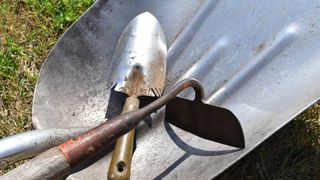 picture of wheelbarrow with hoe and trowel inside it