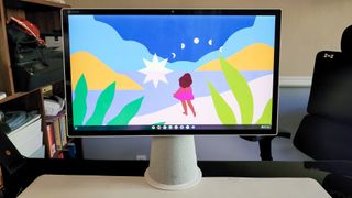 HP Chromebase All-in-One 22 on a standing desk next to its keybooard and mouse