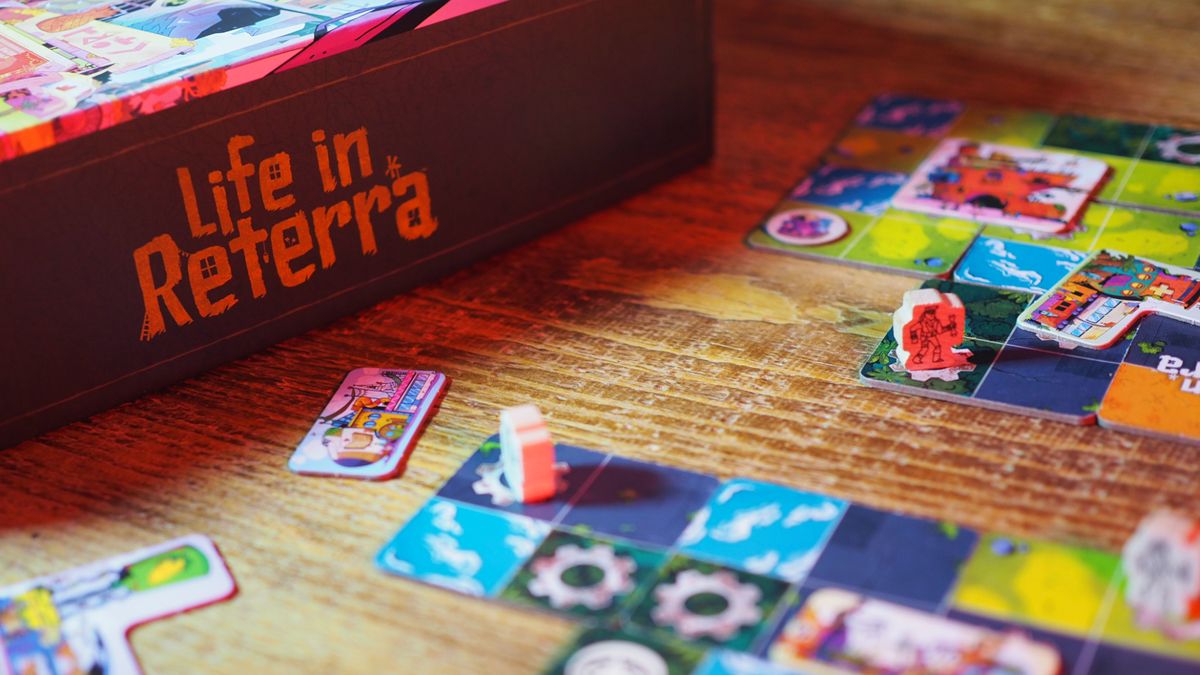 Life in Reterra box, board pieces, and tokens on a wooden table