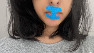 Woman has taped her mouth shut with a blue I shaped mouth tape