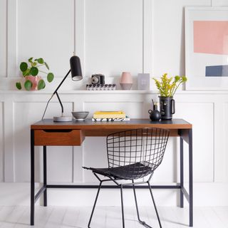 White home office with panelled walls and white painted floor and wooden desk