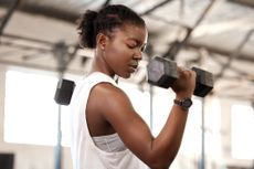 A woman performing a dumbbell curl 