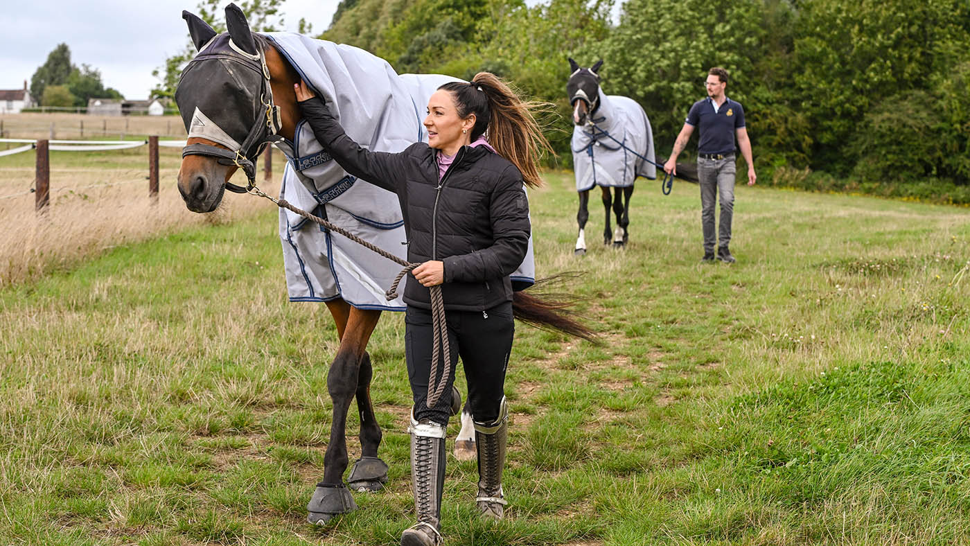Abi Lyle with Giraldo (Arty) and Mark McVicar with Farrell leading them to the fields at her yard, Chimneys, in Stretton-on-Fosse near Moreton-in-Marsh in Gloucestershire