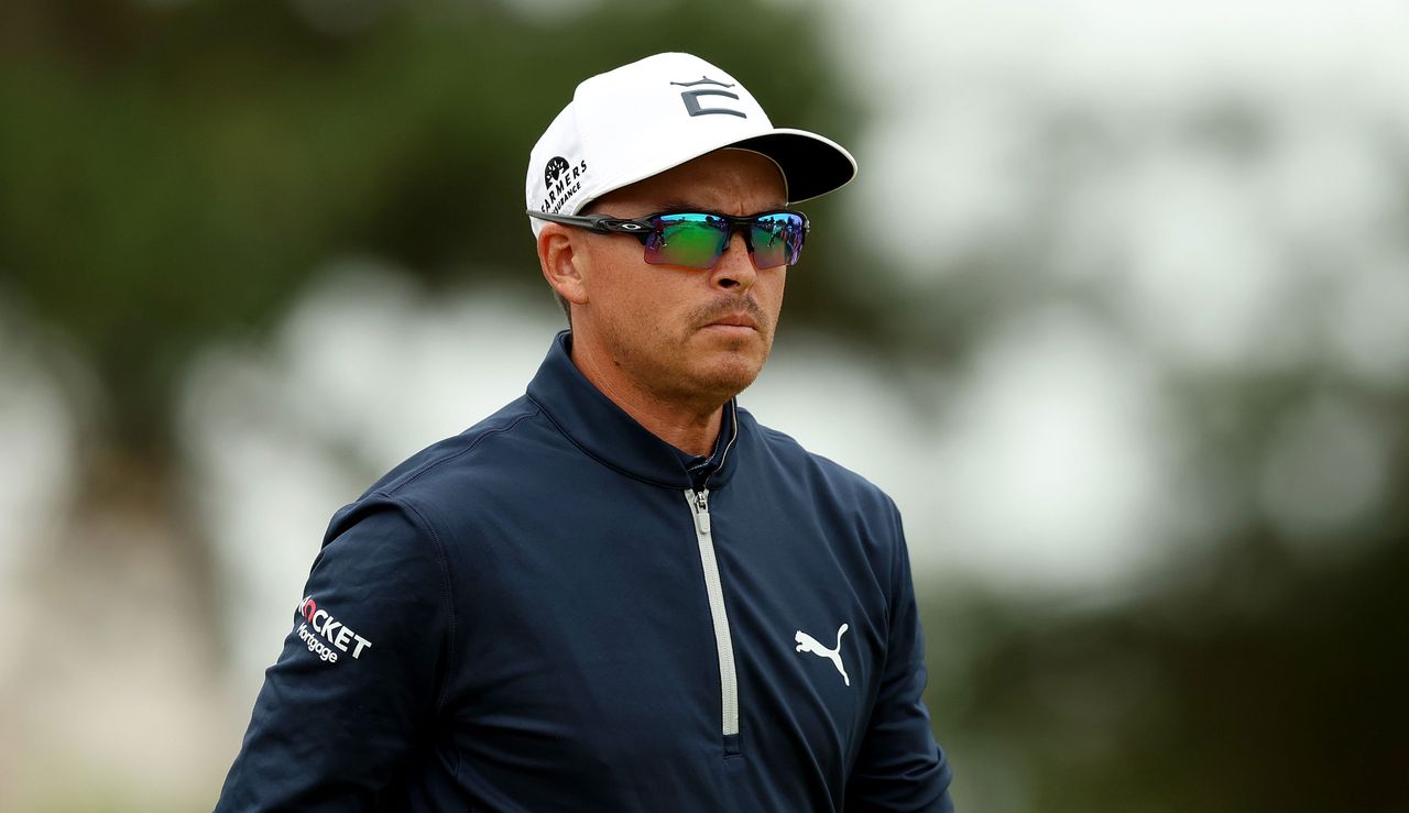 Rickie Fowler looks on in sunglasses