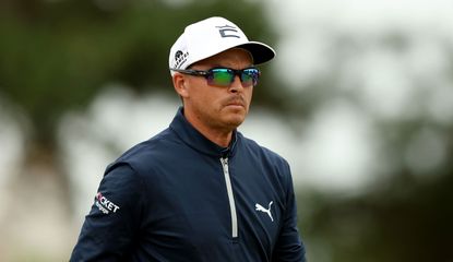Rickie Fowler looks on in sunglasses