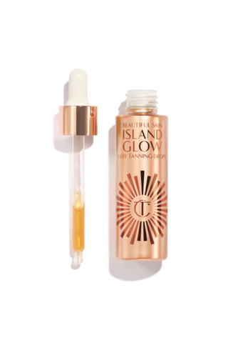 A golden bottle of Charlotte Tilbury Island Grow self-tanning drops against a white background.