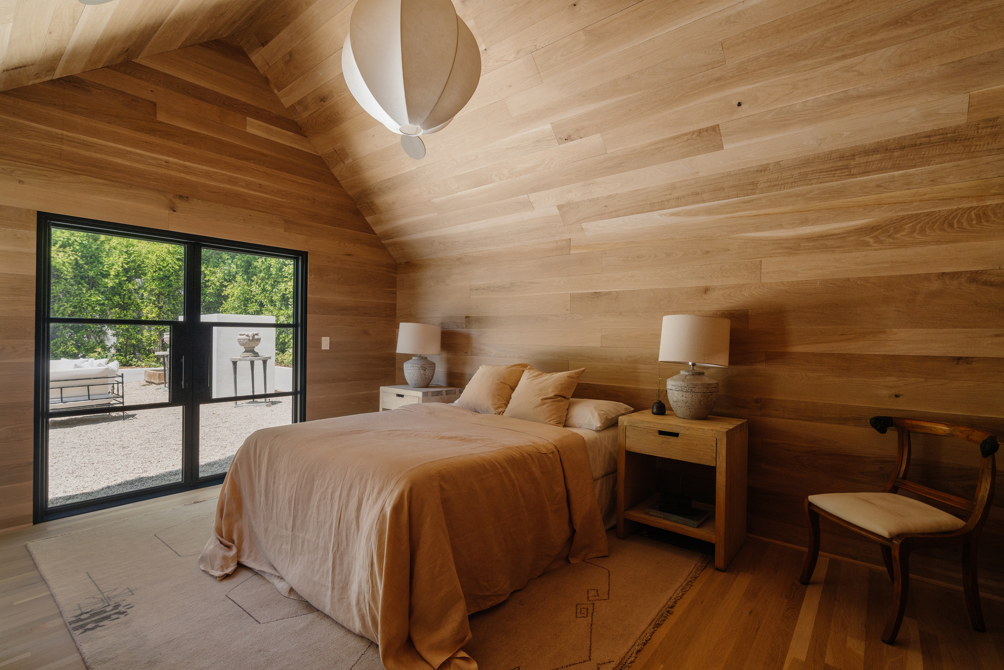 A bedroom clad in wooden wall panelling
