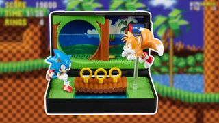 A diorama showing Sonic and Tails in the green Emerald Hills Zone, surrounded by a white border, against a slightly blurred screen shot of a checker environment with green tops and palm trees