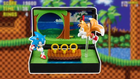 A diorama showing Sonic and Tails in the green Emerald Hills Zone, surrounded by a white border, against a slightly blurred screen shot of a checker environment with green tops and palm trees