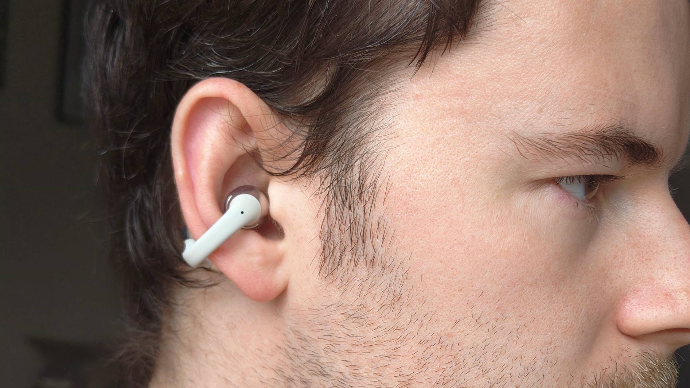 The Shokz OpenDots One clipped into a man's ear.