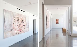 Two images. Left, a large painting of a woman's face on a white wall. Right, a passage with wall paintings, doorways, wooden tables and a shiny floor.