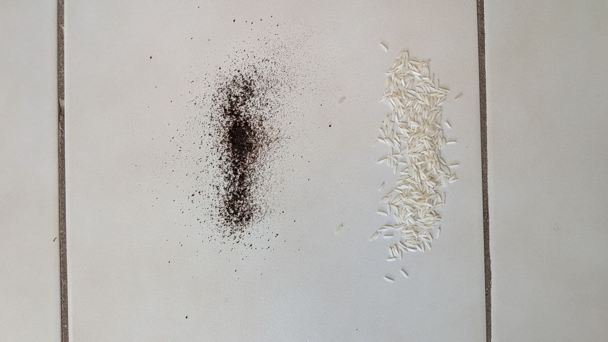 Pile of dry tea and rice on tiled floor before the vacuuming test
