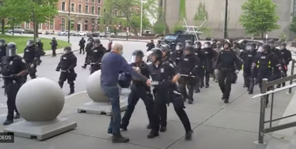 Police shove 75-year-old protester.