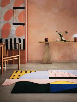 a colorful rug in a terracotta room