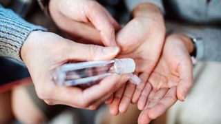 two friends applying hand sanitiser