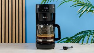 A black Instant Infusion Brew 12-Cup drip coffee maker with a removable water reservoir, glass carafe and reusable coffee filter