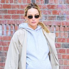 Jennifer Lawrence wearing a hoodie and trench coat