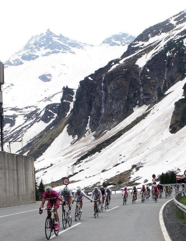 "Riders pass by snowy slopes in Austria."