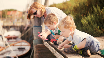 Family sitting on wooden planks concentrating on a crab line