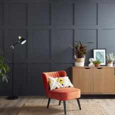 room with grey wall panels wooden flooring and orange chair