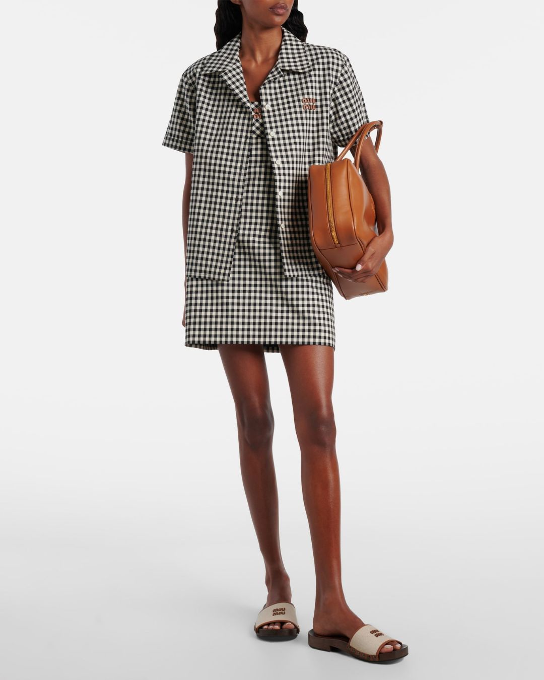 a model wearing a gingham shirt and dress