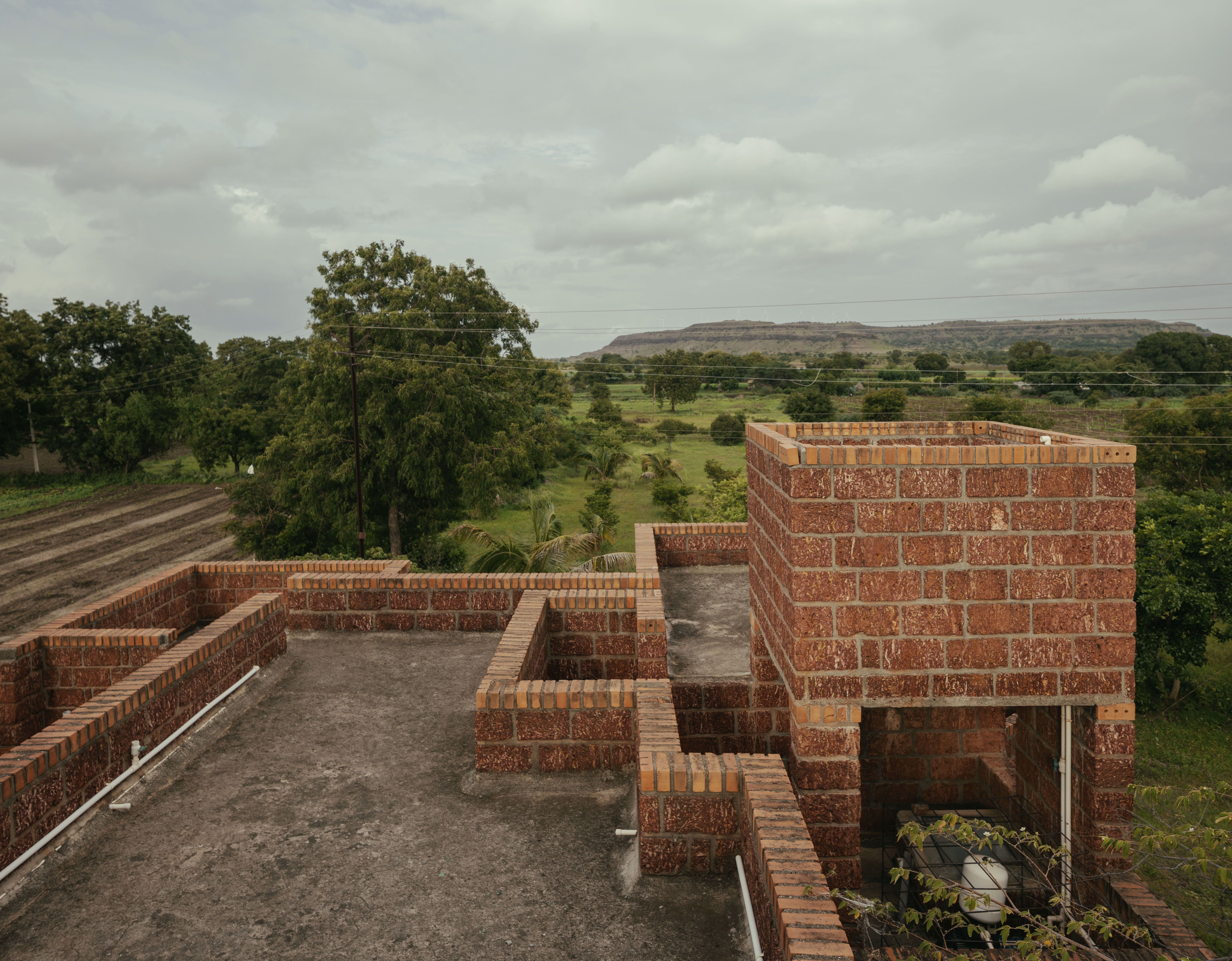 Kanade brothers house in India, brick structure in green surrounds