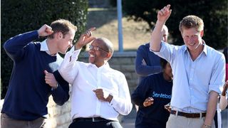 Prince Harry and Prince William dance with Prince Seeiso as they visit the Mamahato Network Club in Lesotho