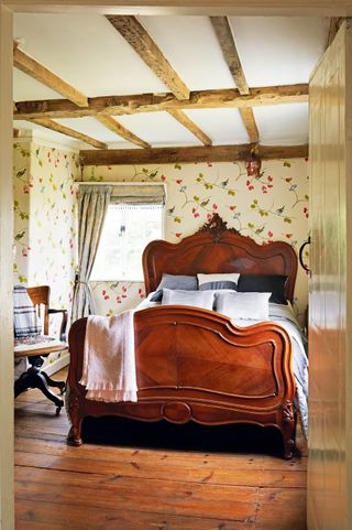 Bedroom with floral wallpaper, wood floor and double bed
