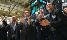 Visitors to the New York Stock Exchange applaud after the Dow Jones and the S&P both hit five-year highs on Jan. 24.