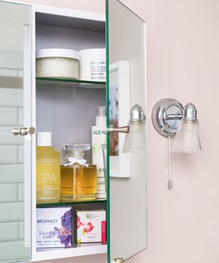 Mirrored bathroom cabinet with toiletries stored inside