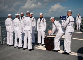 US Navy personnel carry the cremains of Apollo 11 astronaut Neil Armstrong during a burial at sea service aboard the USS Philippine Sea (CG 58), Friday, Sept. 14, 2012, in the Atlantic Ocean.