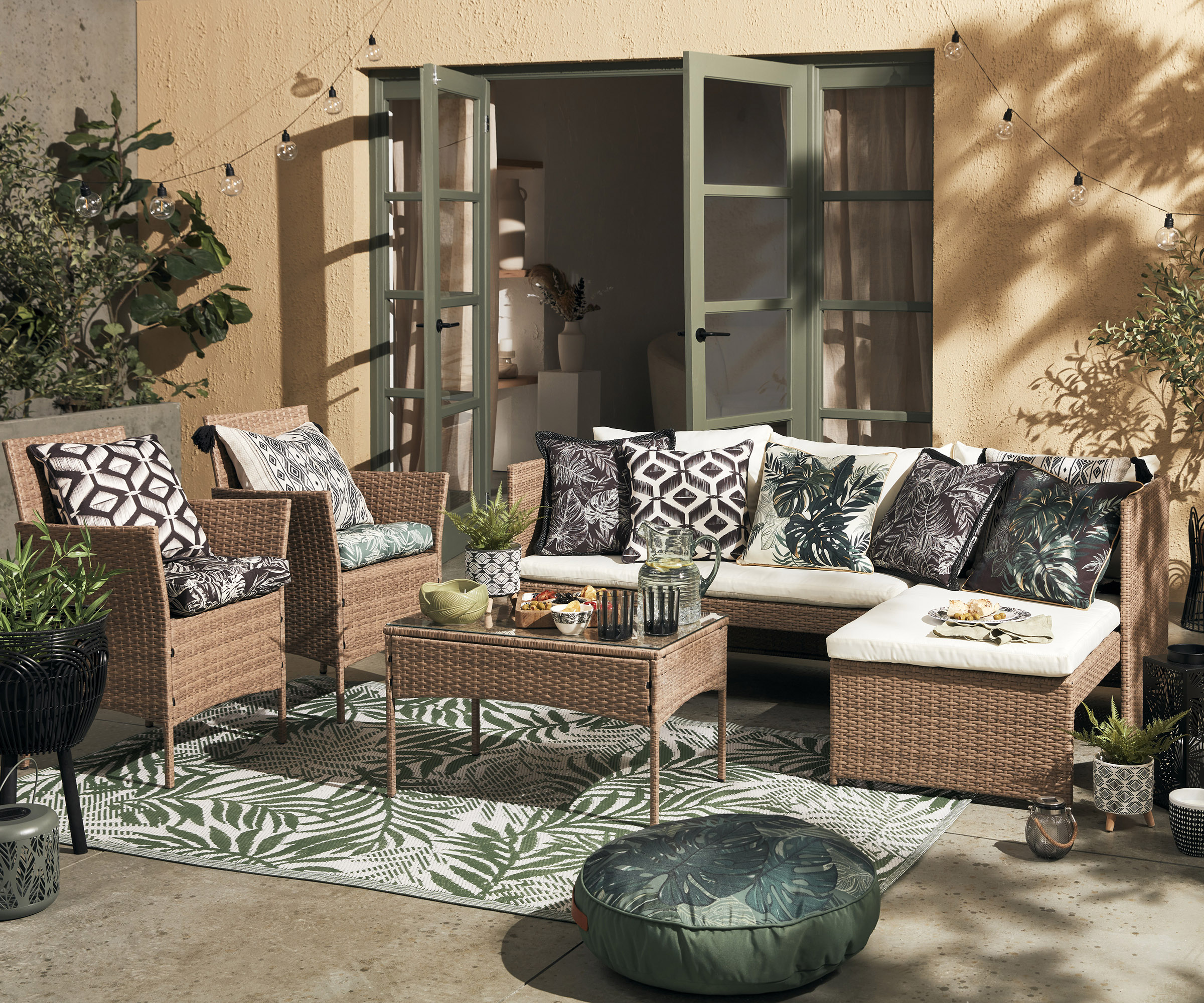 A garden furniture set covered in cushions on an outdoor rug